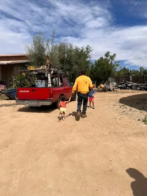 Mi papá, jardinero, caminando con mis hijos hacia su camioneta.